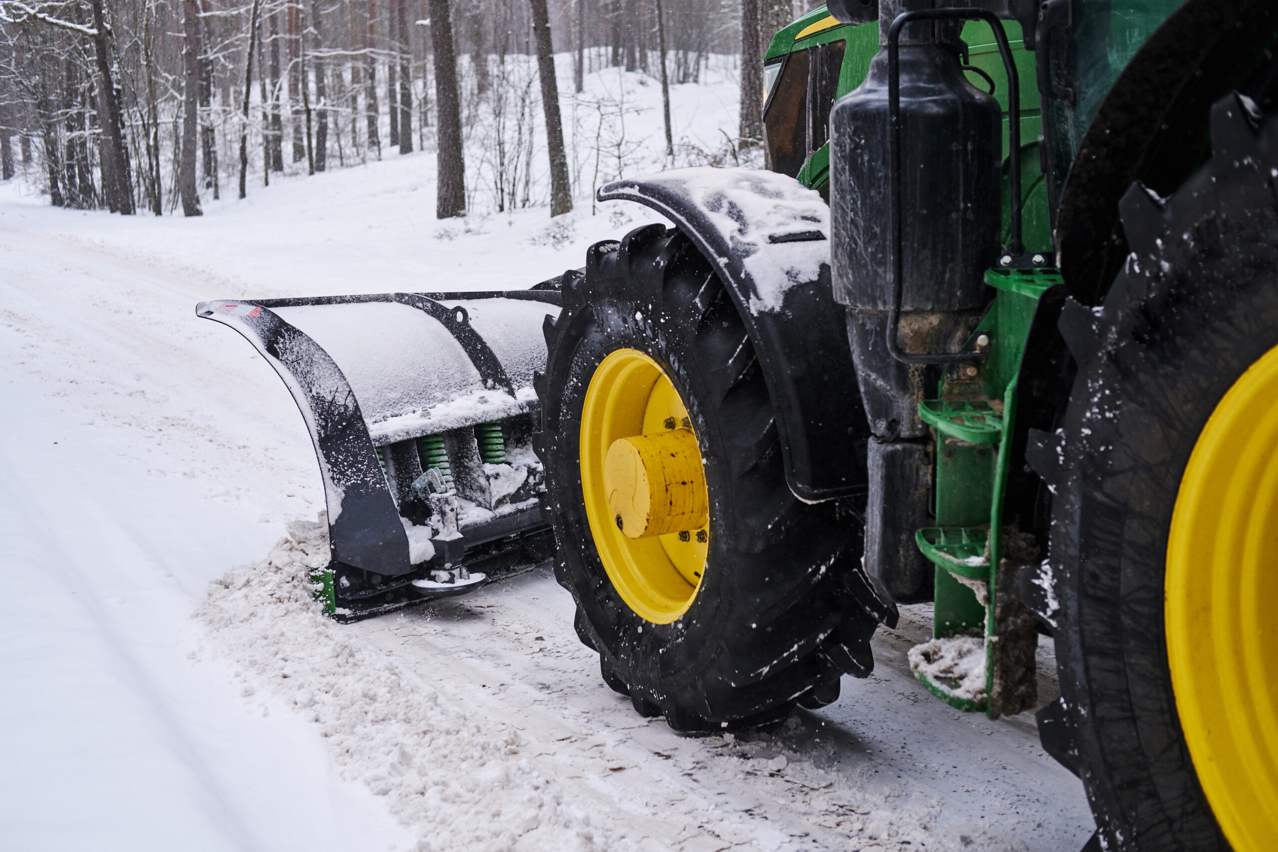 Schneeräum-Traktor räumt eine verschneite Straße im Rahmen des Winterdienstes frei.